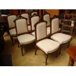 A set of eight late Victorian walnut framed dining chairs, crest carved with coronet and initials.