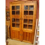 A modern pine glazed cupboard.