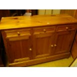 A modern pine sideboard, with three drawers over three cupboard doors.