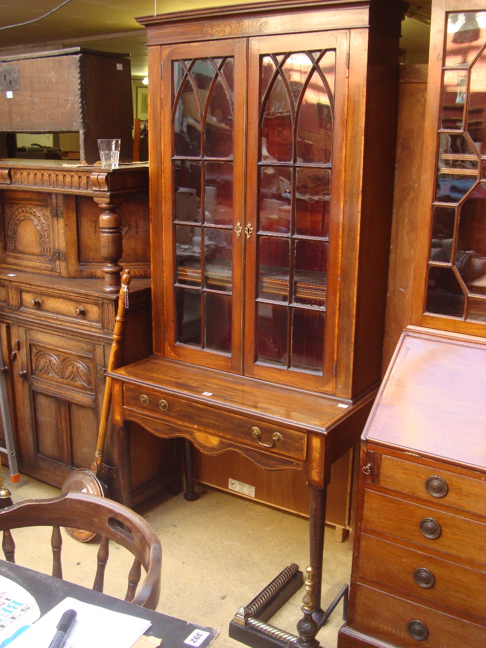 A mahogany astragal glazed bookcase on stand, satinwood banded and inlaid with fan marquetry,