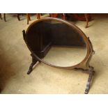 A Georgian style mahogany large oval skeleton swing toilet mirror, on scroll supports.