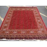 A red ground Bokhara style carpet. 280 x 200cm.