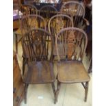 A matched set of seven beech wheelback chairs with solid elm seats, including an armchair.