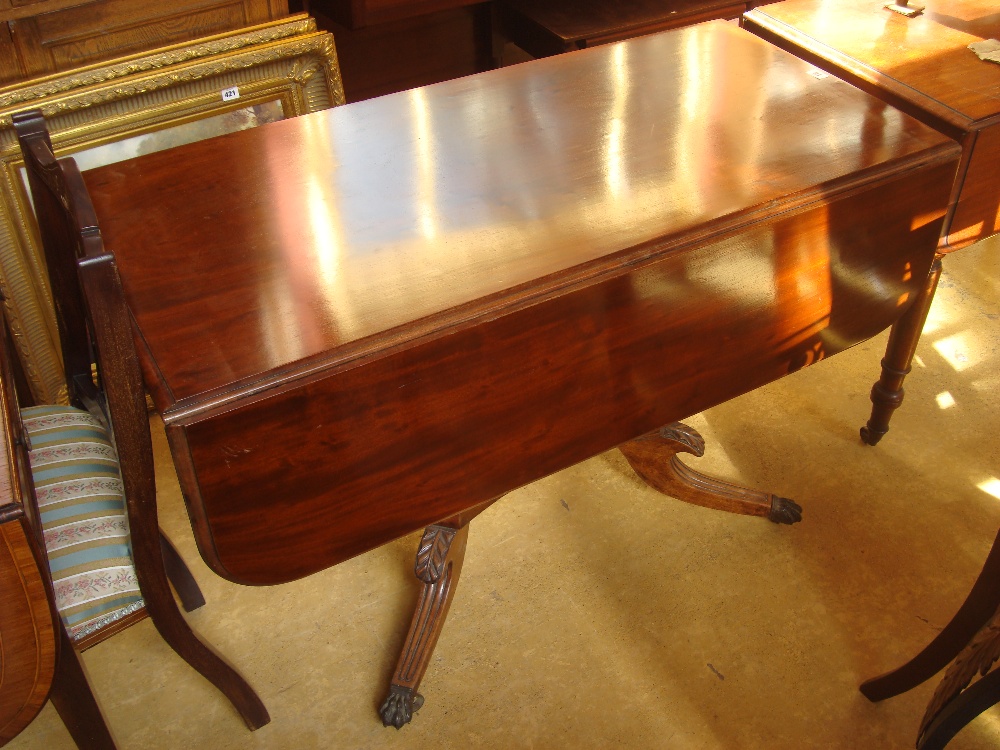 A mid 19th Century mahogany Pembroke table raised on an outswept single stem, quatrefoil legs.