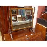 An early 19th Century mahogany rectangular skeleton swing toilet mirror, on turned upright supports.