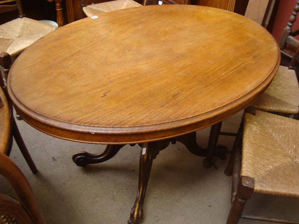 A 19th Century walnut loo table above a shaped support and four foliate carved legs.