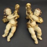 A pair of 19th Century winged putti polychrome wall sconces,