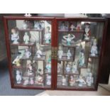 A cabinet display of 19th Century and later ceramics pin doll cushion heads,