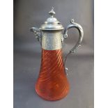 A Victorian cranberry glass claret jug, the writhen body with pewter handle and lid with mask spout,