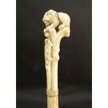 A 19th Century bone walking cane with an ivory top in the form of a crouching lion,