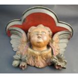 A 19th Century polychrome wall clock bracket with carved winged cherub decoration,