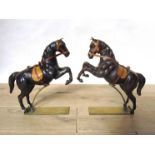 A near pair of Austrian rearing horses on brass stands, leather over papier maché.