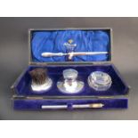 A silver writing desk set comprising capstan inkwell, quill, powder brush,