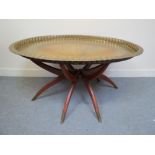 A Scandinavian mid-century modern oval brass tray on folding spider leg base