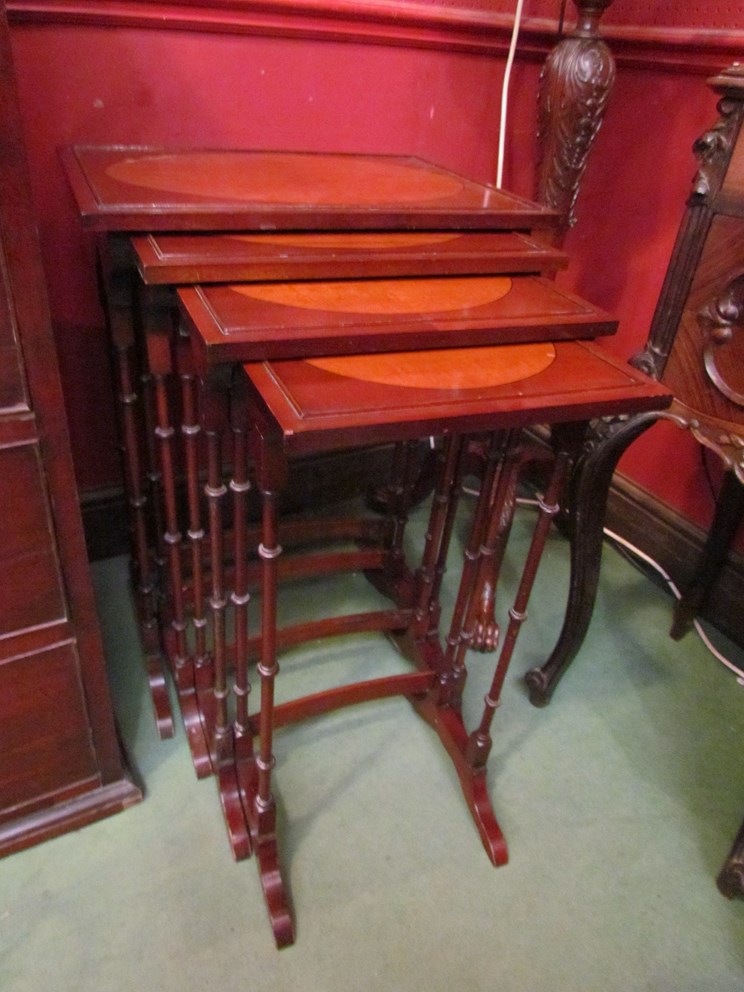 A nest of four mahogany tables with oval inlay to top,