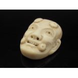 A 19th Century noh-mask ivory netsuke with signature to reverse, 4.