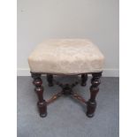 A Victorian serpentine stool with silk upholstered over stuffed seat,