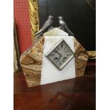 A French Art Deco mantel clock surmounted by birds in onyx and marble case with lozenge silvered