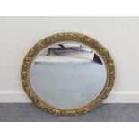 A 20th Century bevel edged circular wall hanging mirror with gilt frame foliage decoration,