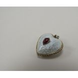 A white guilloche heart shaped pendant with cabochon ruby set to centre