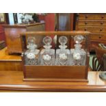 A 20th Century mahogany Tantalus with four decanters