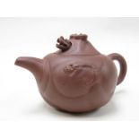 An Oriental terracotta teapot with moving dragons head to lid,