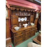A 17th Century revival oak dresser with pierced decoration over a shelved back having two drawers