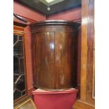 A 19th Century mahogany barrel corner cupboard with shelved interior,