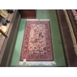 An Eastern wool rug depicting hunters on horseback with birds,