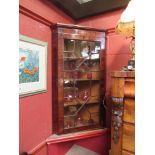 A George III mahogany wall hanging corner cabinet with single astragal glazed door with key,