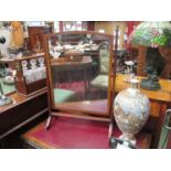 An Edwardian mahogany table top swing mirror with reeded supports to splayed feet,