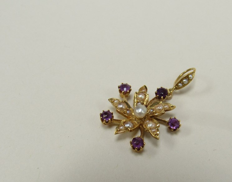 An Edwardian gold floral burst pendant set with pearls and amethysts