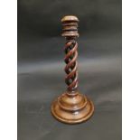 A 17th Century style walnut candlestick with spiral twist column on a two height turned circular