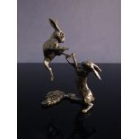 A pair of miniature bronze boxing hares,