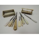 A Georgian bone brush and small pierced basket together with button hooks and other dressing items