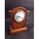 A 19th Century oak mantel clock, domed top, with Roman numeral dial column supports,