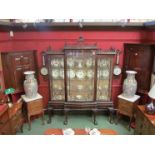 A late 19th/early 20th Century mahogany display cabinet of pagoda form (one pane cracked) in the