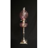 A Victorian silver plated oil lamp with cranberry floral etched shade and reservoir,