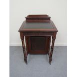 In the manner of "Maple & Co" a Victorian mahogany Davenport with blind fret decoration the