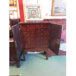 A Georgian mahogany two door cabinet on stand, drop brass handles on chamfered legs,