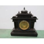 A black marble mantel clock of architectural form, brass chapter ring with visible escapement,