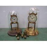 Two brass anniversary clocks under glass domes