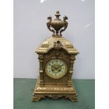 A French decorative brass mantel clock with urn finial,