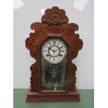 An American oak and carved "gingerbread" style mantel clock with Roman dial and 8 day movement,