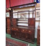 A Late 18th Century oak dresser, the upper section having shelves and two small cupboards,