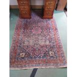 A 20th Century handwoven care worn Persian rug with central floral medallion, multiple border,