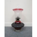 A Victorian oil lamp with Art Nouveau shade, cranberry reservoir,