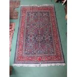 A 20th Century handwoven Persian rug with central floral field, multiple borders,