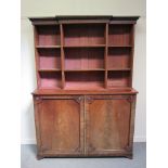 A Georgian mahogany bookcase with breakfront shelf top over two door base, roundel detail,