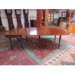 A George III mahogany dining table with folding top and two extra leaves,